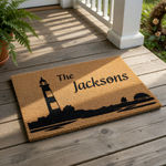 Personalized lighthouse doormat with custom family name, featuring a coastal nautical design on natural coir fiber.