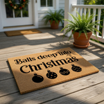 Funny Christmas doormat with a natural coir texture, featuring the bold text Balls deep into Christmas and four decorative holiday ornament icons, making this a cheeky seasonal welcome mat for your front porch or entryway decor.