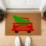 a door mat with a christmas truck with a tree on it