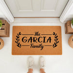 Personalized family name coir doormat featuring a black leaf branch design on a natural fiber welcome mat, perfect for a front porch entryway, housewarming decor, or custom home entrance floor rug for a new house or apartment.
