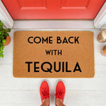 Funny Come Back With Tequila doormat featuring bold black text on a natural coir fiber welcome mat, placed on a white porch in front of a red door, perfect for a humorous home entrance or a fun housewarming gift for alcohol