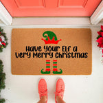Funny Christmas doormat with Have Your Elf a Very Merry Christmas text, featuring a green elf hat and striped legs design on natural coir fiber, perfect for holiday porch decor and festive front door welcome mat entryway styling.