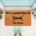 Funny doormat with text It is a good day to knock crossed out and go away printed on natural coir fiber.