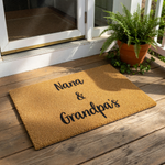 Nana and Grandpa's personalized coir doormat, a natural fiber welcome mat for the front porch featuring custom family text in black script, ideal for a housewarming entry decor piece for grandparents to greet their visiting