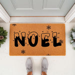 Noel Christmas doormat featuring snowy black lettering and snowflake accents on a natural coir fiber mat, perfect for holiday porch decor and winter entryway styling to welcome guests to your home during the festive season.