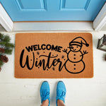 Welcome Winter snowman doormat featuring a festive holiday design on natural coir fiber, perfect for seasonal porch decor, front door entryways, and winter home styling with a cute snowman graphic and bold black lettering.