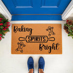 Baking Spirits Bright Christmas doormat featuring cute gingerbread men and a rolling pin design on natural coir fiber, perfect for a festive holiday porch entrance decor or a seasonal welcome mat for your front door entryway.