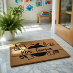 Personalized teacher doormat with school supplies design on natural coir fiber, featuring a custom name area for a classroom entrance or front porch decor, making a thoughtful gift for educators and school staff members.