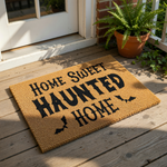 A textured door mat with the text "HOME SWEET HAUNTED HOME" printed on it.