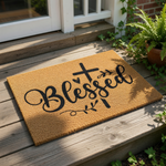 A mat with the word "Blessed" written on it, along with a cross and some decorative elements.
