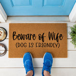 a door mat that says beware of wife dog is friendly