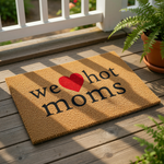 A textured doormat with the phrase "we heart moms" printed on it, along with a red heart symbol.