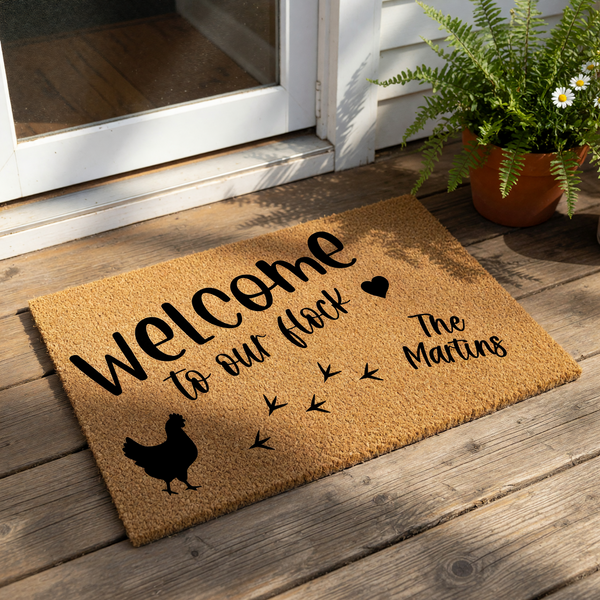 a mat with a welcoming message that reads "Welcome to our flock" and includes a silhouette of a chicken and some chicken feathers.