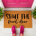 a door mat that says shut the front door