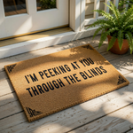 A textured doormat with the phrase "I'm peeking at you through the blinds" printed on it.