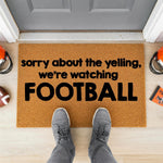 a door mat that says sorry about the yelling, we're watching football