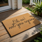 A textured doormat with the phrase "Oh no! not you again" printed on it.
