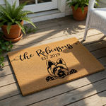 A rectangular, light brown doormat with a black dog illustration and text printed on it.