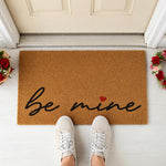 a door mat that says be mine on it