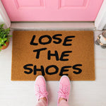 a door mat with the words lose the shoes written on it