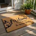 A welcome mat with a pig illustration and the text "Welcome The Lawson Family" printed on it.