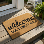 A welcome mat with the text "welcome DON'T EXPECT MUCH" printed on it.