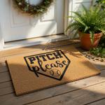 A door mat with the text "PITCH please" printed on it, along with a baseball graphic.