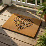A heart-shaped doormat with a leopard print pattern on it.