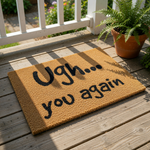 A textured area rug with the phrase "Ugh... you again" printed on it.