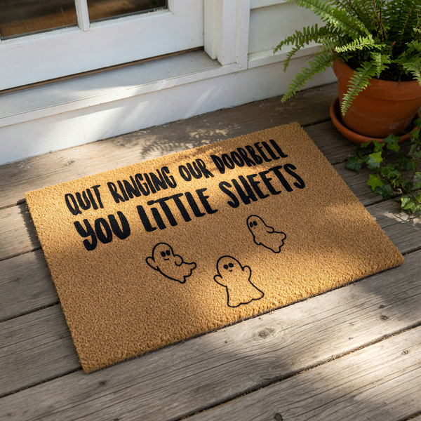 a doorbell mat with a humorous text that reads "Quit ringing our doorbell you little sheets".