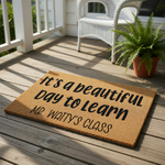 A door mat with the text "It's a beautiful day to learn Mr.