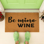 a door mat that says be mine wine
