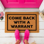 a door mat that says, come back with a warrant