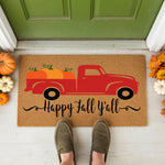 a happy fall y'all door mat with a red truck
