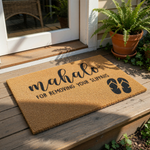A textured area rug with the text "Mahalo" and "FOR REMOVING YOUR SLIPPAH" printed on it, along with a pair of black flip-flops.