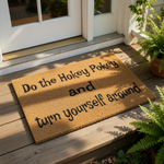 a rectangular, beige-colored doormat with black text that reads "Do the Hokey Pokey and turn yourself around".
