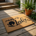 A textured area rug with the phrase "probably at the Lake" printed on it.