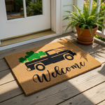 A black truck with a shamrock on its bed is depicted on a welcome mat, accompanied by the word "Welcome".