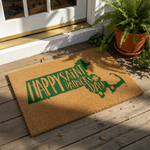 A door mat with a green graphic design that says "Happy Saint Patrick's Day" in a stylized font.