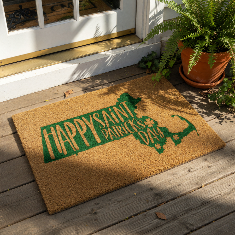 A door mat with a green graphic design that says "Happy Saint Patrick's Day" in a stylized font.