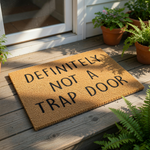 A textured door mat with the text "Definitely Not a Trap Door" printed on it.