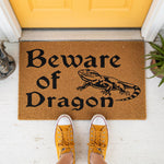 a door mat that says beware of the dragon