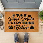 A textured door mat with the phrase "Dogs Make Everything Better" printed on it, along with paw prints and a dog's head.
