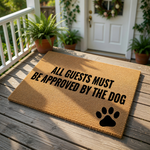 A textured doormat with the text "ALL GUESTS MUST BE APPROVED BY THE DOG" printed on it, along with a paw print symbol.