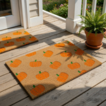 a rectangular mat with a repeating pattern of orange pumpkins on a beige background.