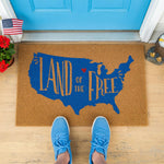 a door mat with the words land of the free on it