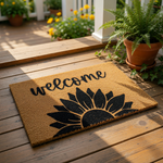 A welcome mat with a sunflower design and the word "welcome" written on it.