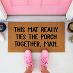 a door mat that says, this mat really ties the porch together, man