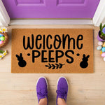 a welcome pees door mat hanging on a door