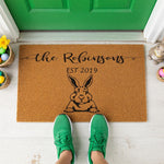 A wooden door mat with a black rabbit illustration and text that reads "the Robinsons EST 2019".